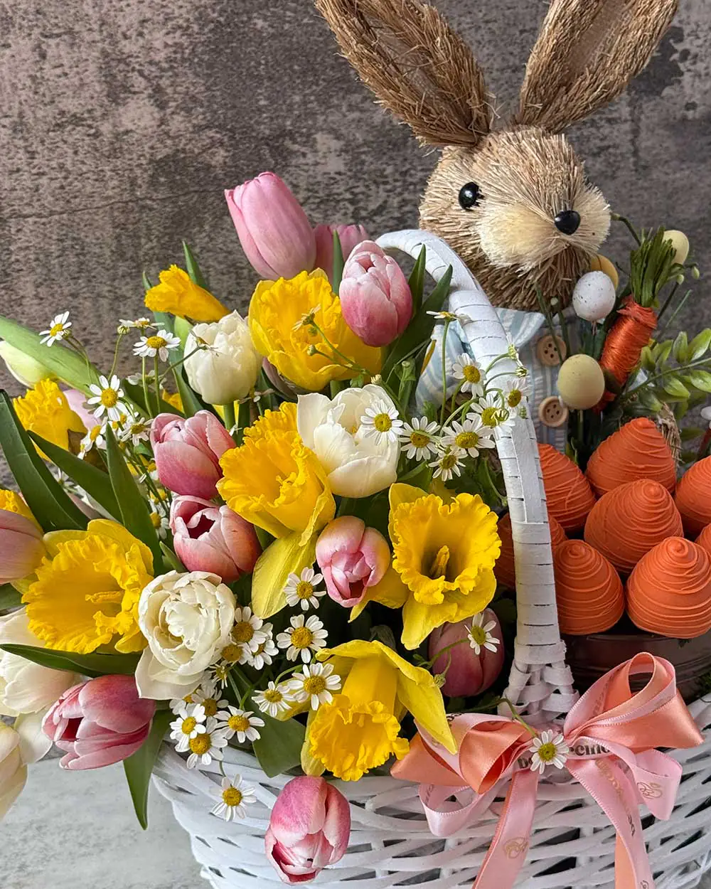 White woven basket filled with tulips, narcissus, spring mix, and Easter bunny