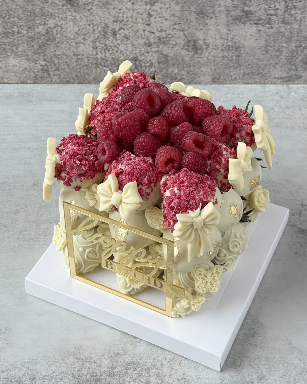 Luxury birthday cake with molded chocolate bows and gold accents