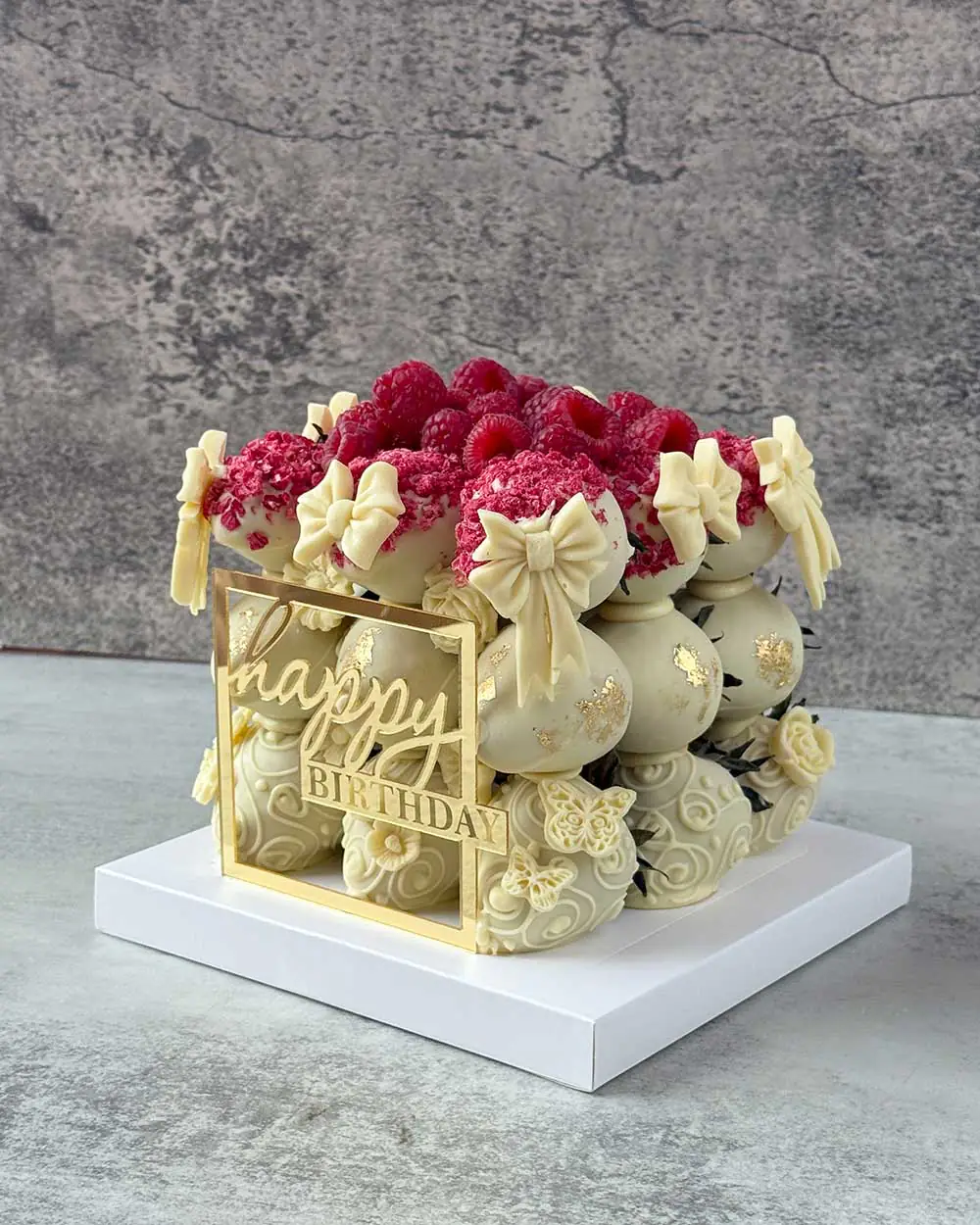 Elegant chocolate strawberry cake topped with fresh and dried raspberries