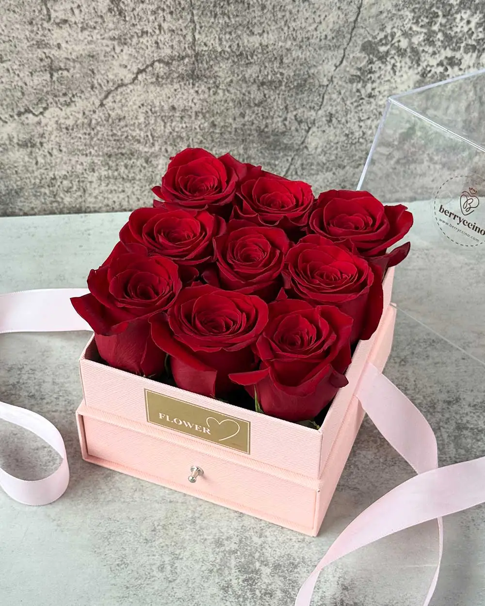 Close-up of chocolate-covered strawberries and roses in pink gift box