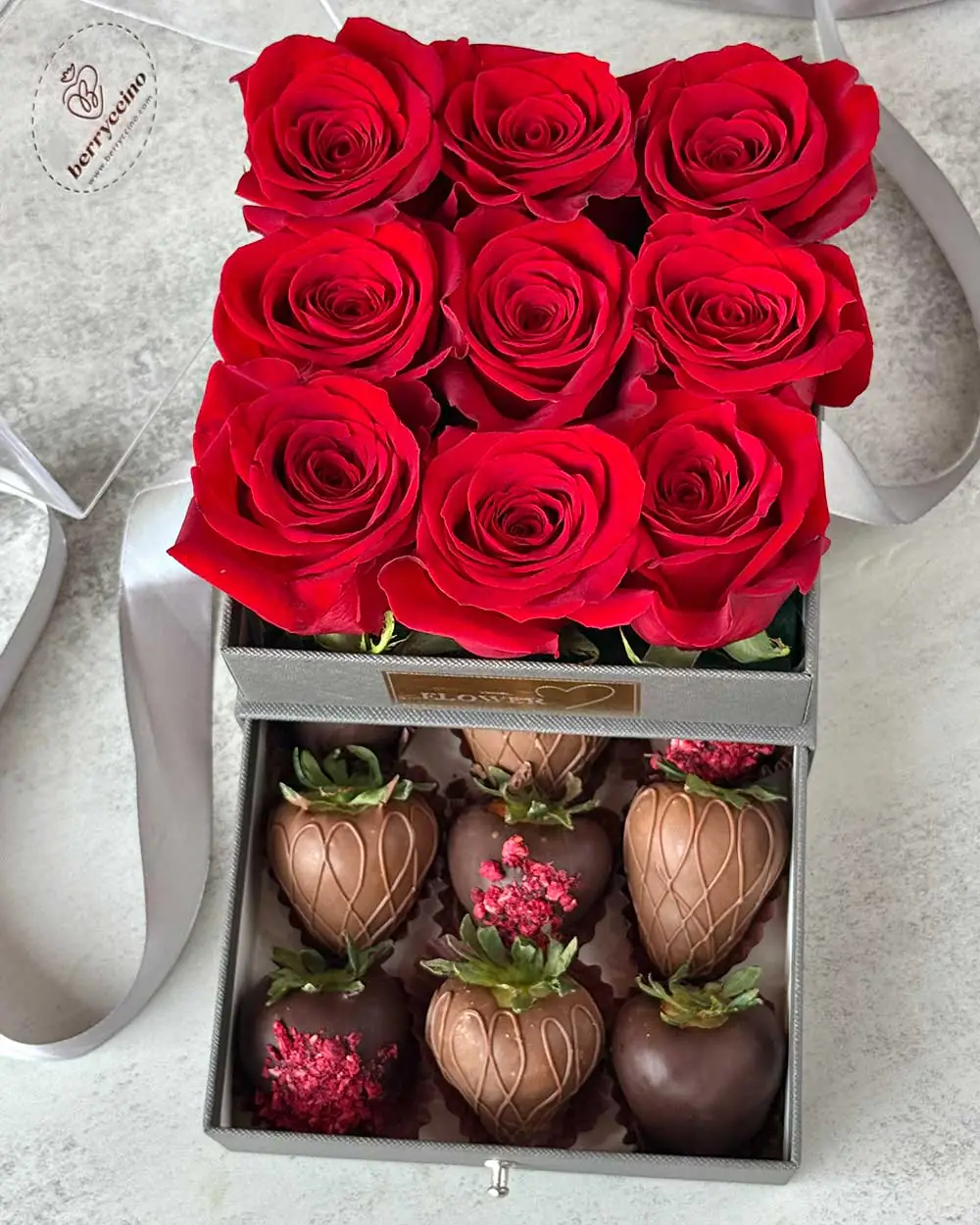 Close-up of handcrafted chocolate strawberries and roses in gray gift packaging